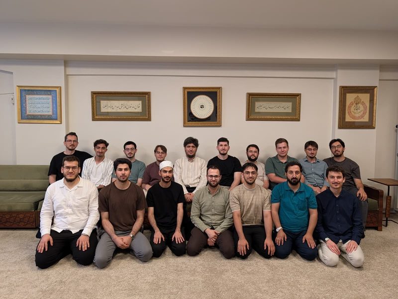 Kamp katılımcıları vakıf merkezinde hat levhalarının önünde toplu hâlde